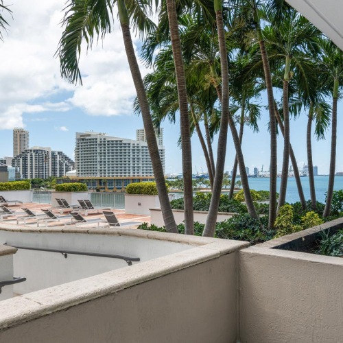a white wall with trees and buildings in the background